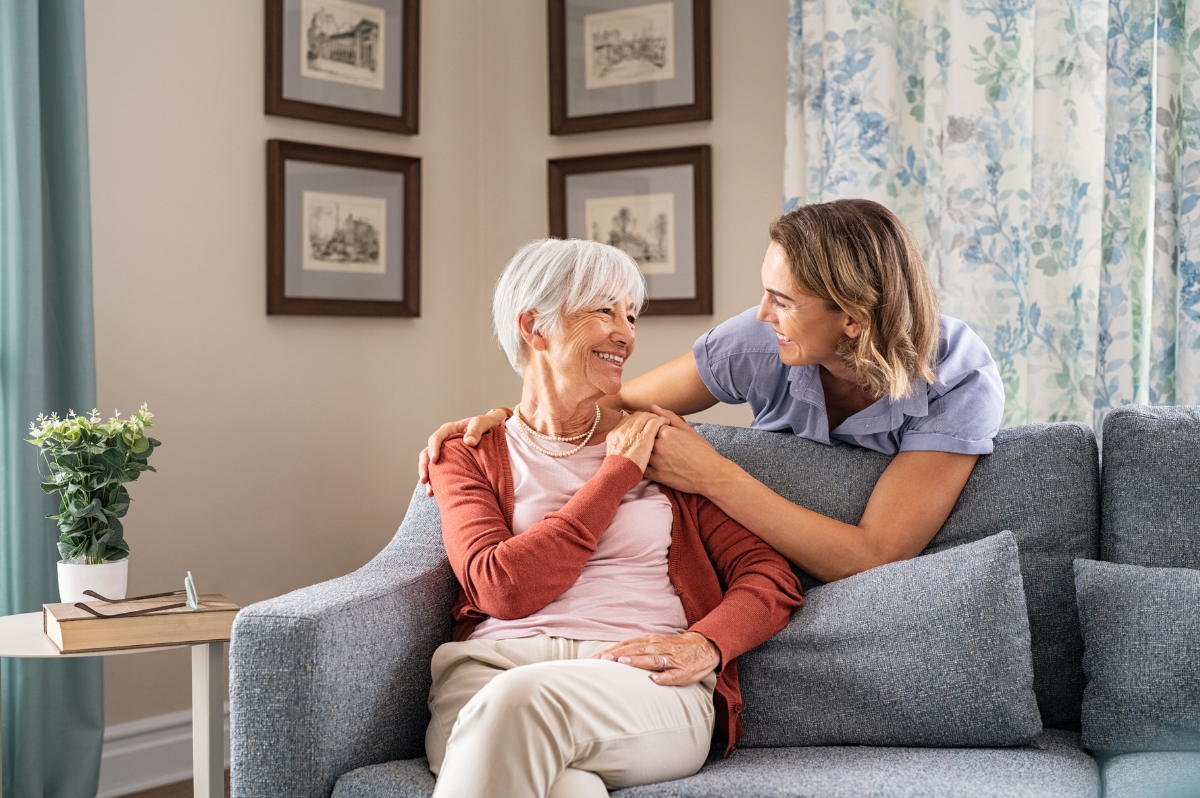 Daugther and mother embracing around a couch