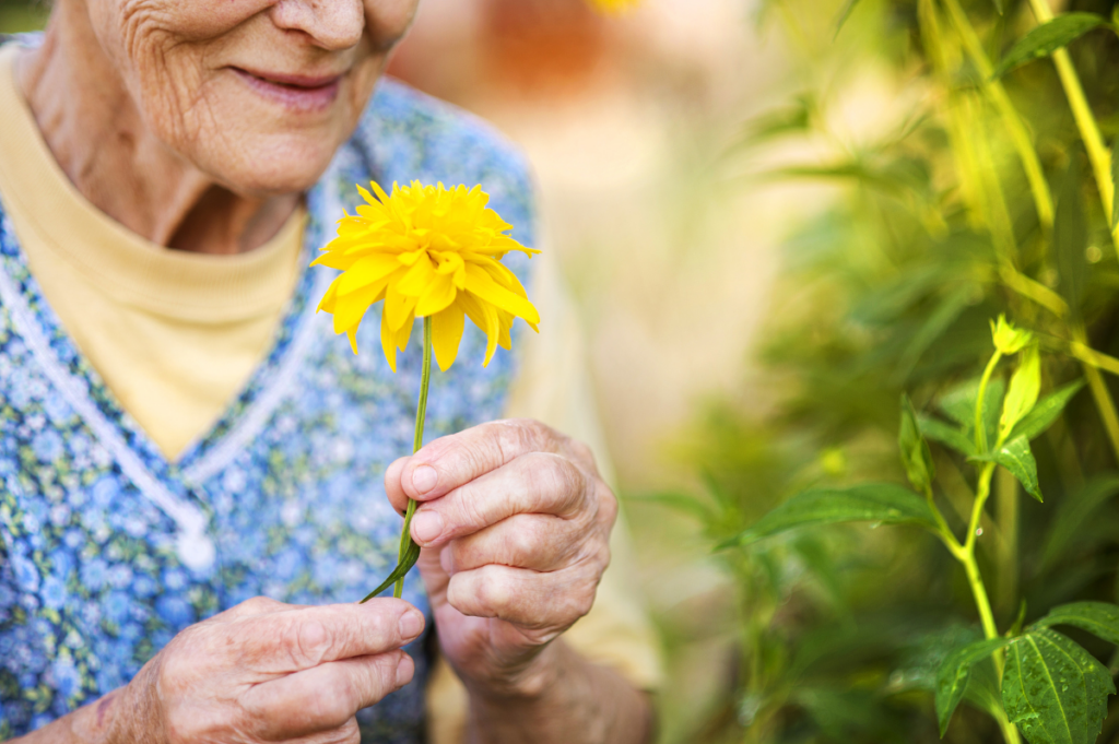 woman smelling a yellow flower