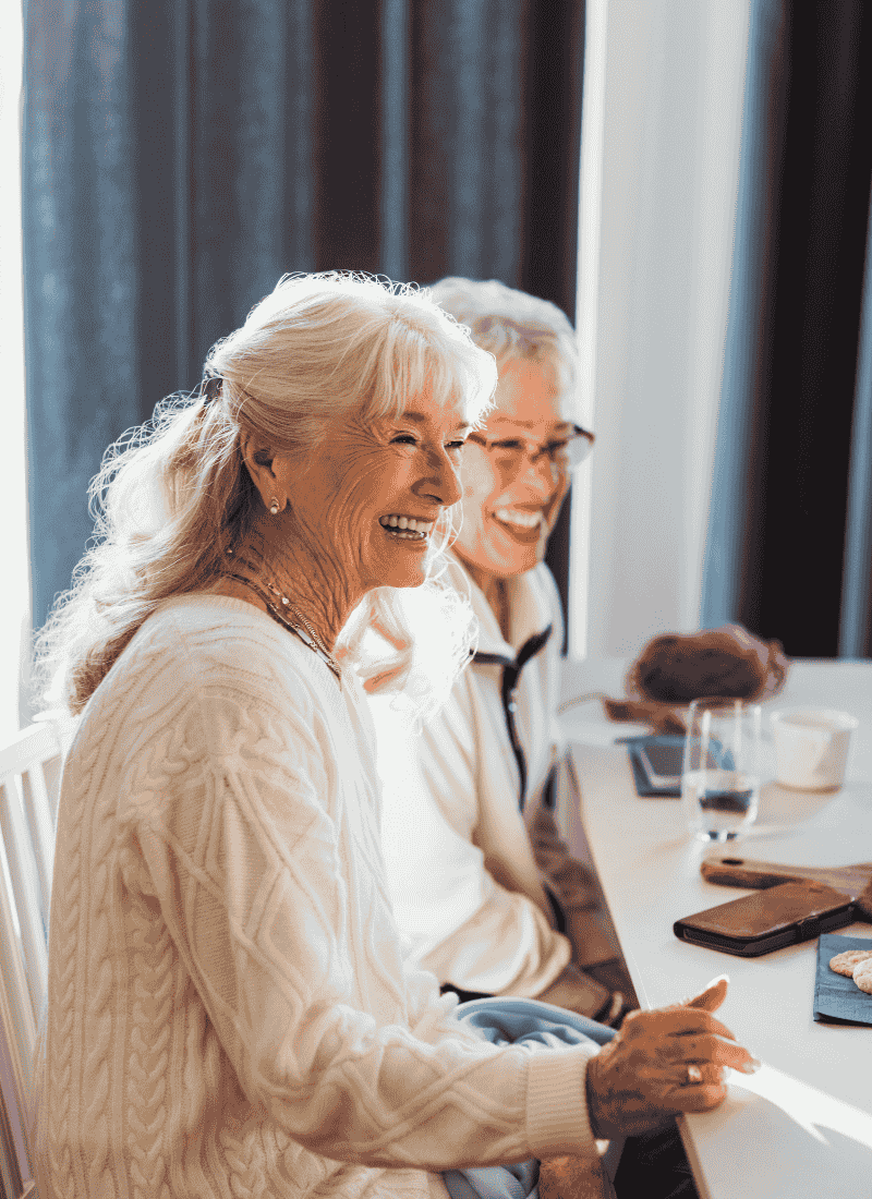 Two woman laughing at a table